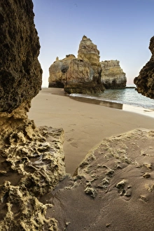 Portugal Coastal Scenery Drucke: A sea cave frames the ocean and the imposing cliffs at dawn, Praia da Rocha, Portimao