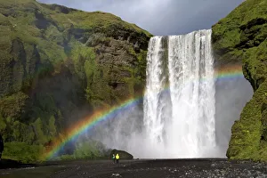 Drucke von Wasserfall Skógafoss mit Regenbogen im Sommer-Sonnenschein an der Südküste Islands. Polarkreise Island Drucke: Wasserfall Skógafoss mit Regenbogen im Sommerunwetter am Südküsten-Iceland-Polarregion