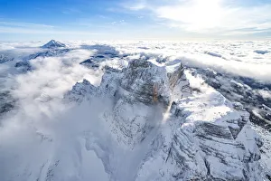Veneto Region Italy Tourism Drucke: Snow capped Monte Pelmo emerging from clouds, aerial view, Dolomites, Belluno province