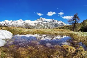 Snowcapped Mountains Europe Drucke: Snowcapped mountains reflected in a pristine lake in springtime