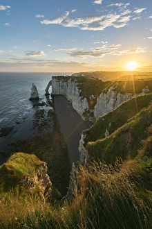 Normandy Coastal Scenery Drucke: Sun rays at dawn at the cliffs, Etretat, Normandy, France, Europe