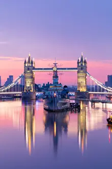 London Skyline At Dawn Drucke: Sunrise view of HMS Belfast and Tower Bridge reflected in River Thames
