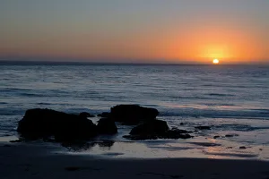 California Coastline Images Drucke: Sunset over the ocean, with rocks in the foreground
