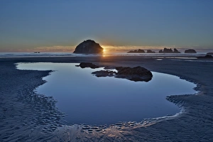 American Nature Scene Drucke: Sunset by a sea stack over a pool on the beach
