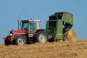 Sussex Countryside Scene Drucke: Tractor towing baler unloading drum bale, Wannock, Sussex, England, United Kingdom