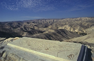 Drucke von Blick von Klippe mit beschreibender Karte auf Steinplatte im Vordergrund und Hügeln dahinter; Wadi Qelt; Judäischer Sandesert; Israel; Naher Osten Karte Drucke: Blick vom Kliff mit beschreibender Karte auf Stein gemeißelt