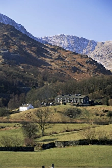 Cumbrian Landscapes Photography Drucke: View across fields to cottages and snow-capped mountains, Little Langdale