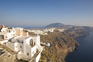 Blick entlang vulkanischer Klippen nach entfernten Fira und Imerovigli auf die Inseln der Kykladen vor dem Mittelmeer in Griechenland