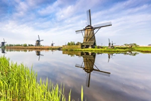 Drucke von Windmühlen Spiegel auf dem Kanal und Gras im Vordergrund. Kinderdijk Eintrag als Weltkulturerbe der UNESCO. Molenwaard Gemeente in Südholland Provinz Niederlande Europa Bilder Datiert 2017 April: Windmühlen Spiegel am Kanal und Gras im Vordergrund, Kinderdijk, UNESCO