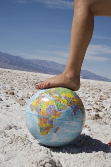 Arid Landscape Images Drucke: Womans foot on globe