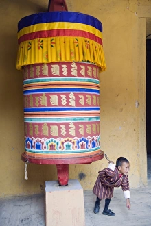 Drucke von Junge Junge, der einen Gebetswagen zieht, Jakar Dzong, Schloss der weißen Vögelin, Jakar, Bumthang, Chokhor-Tal, Bhutan, Asien Bhutan Drucke: Jüngerer Junge zieht einen Gebetstrichter, Jakar Dzong, Schloss der weißen Vögelin.