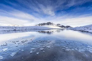 Mountain Pass Scenery Drucke: Clouds is reflected in the icy surface of alpine lake. Stelvio pass, Valtellina, Lombardy
