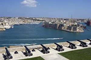 Drucke von Malta, Valletta. Die Kanonen der Batterie auf dem hohen Verteidigungswall von Valletta schützen den Eingang zum Großen Hafen und blicken über die Richtung von Vittoriossa hinweg Malta Drucke: Malta, Valletta