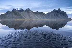 Die Berge spiegeln sich auf der Oberfläche des Ozeans wider. Stokksnes, Ost-Izland, Europa