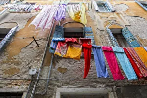Mediterranean Country Scenery Drucke: Multicolored laundry hangs in front of an old facade, Venice, Veneto, Italy