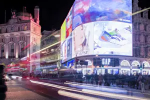 Ein Nachtschuss von Lichtspuren vor den Werbeplakaten im Piccadilly Circus