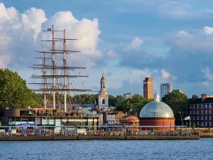 Blick über den Fluss Themse nach der Cutty Sark Britische Segelschiff und der St. Alfege Kirche im Grünewald von London, England Vereinigtes Königreich