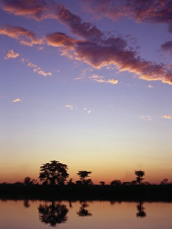 African River Scenery Drucke: The last rays of the setting sun over the Okavango River at Rundu