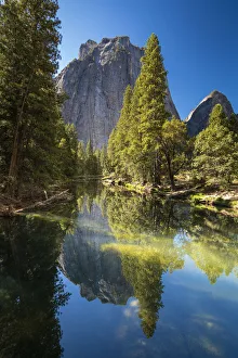 Spiegelung der Bäume im Fluss Merced vor den Kathedralschrofen im Yosemite-Nationalpark