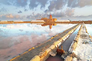 Sonnenuntergangsreflexion am Salzflächen mit der alten Windmühle Saline dello Stagnone in Marsala im Provinztragen von Sizilien Italien