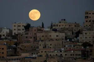 Der Mond wird vor einem lunaren Sonnenuntergang über Amman gesehen