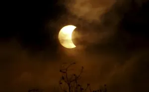 Ein teilweiser Sonnenfinsternis wird durch Wolken im Bangkok gesehen