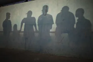 Schatten werfen sich auf die Wand eines Stadions, als Menschen eine traditionelle Ringkampfsportart verfolgen