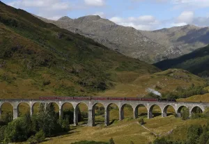 Der Jacobitische Dampfzug überquert das Glencoe-Brückenkopf im Schottland