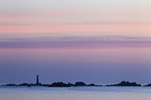 Guernsey Coastline Drucke: View of coastline with lighthouse at sunset, L Eree Bay, Guernsey, Channel Islands, May