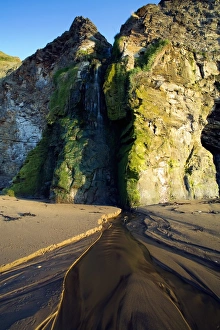 North Yorkshire Waterfalls Drucke: Waterfall flowing from cliffs onto sandy beach