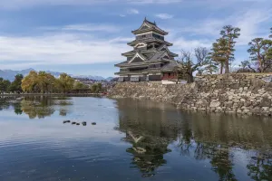 Die Reflexion des Matsumoto Castells und das Schloss gegen den Berghintergrund im