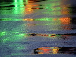 Lichter spiegeln sich im Becken auf dem Asphaltweg wider