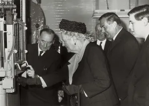 Lady Spencer Churchill betätigt den Knopf, um die Prägung einer Münze mit dem Bild ihres Ehemannes zu beginnen. Auf dem Foto erscheint sie begleitet vom Schatzkanzler Mr. Callaghan am 9. September 1965.