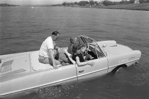 Präsident Lyndon Johnson nimmt Gäste mit auf eine Fahrt in seinem Amphicar.