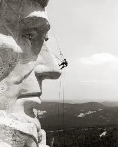 Wahrzeichen Und Denkmäler Drucke: Erklimmen des Gesichts von Präsidenten Abraham Lincoln am Mount Rushmore National Memorial im Südwesten der USA