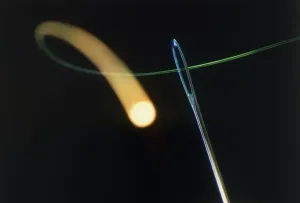 Fibre Optic Cable Drucke: Fibre optic cable being passed through eye of needle