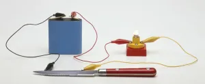 Science Experiment Setup Drucke: Testing for conductivity using a battery connected by a lead to a small light bulb