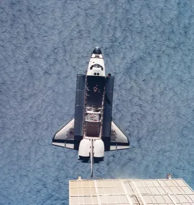 Erhöhter Blick auf die Raumfahrzeuge im Weltraum, das Erdgebiet unter ihm zu sehen ist mit dem Frachträumen offen