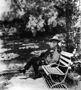 Drucke von Der französische Impressionistenmaler Claude Monet (1840 - 1926) sitzt auf einem Sitzplatz neben dem Wasserlilienbecken in seinem Hausgarten Giverny, Frankreich, Ende der 1910er Jahre Claude Monet Drucke: Klaus von Meunz Sitzt Auf einem Parksitzplatz