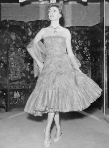 Drucke von Gezeigt ist eine Schöpfung aus der Herbst-Wintersammlung 1957/58 von Gabrielle Chanel nach Paris. Es handelt sich um einen kurzen Rockabendkleid in Aprikosenweißer Seide Mode Drucke: Kokochanel-Rockzeug