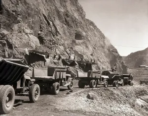 Drucke von (Bild zeigt Dumptrucks am Fuße eines Berges, wo Männer beim Bau der Boulder-Damme (heute bekannt als die Hoover-Damm) arbeiten) Eine zeitlose Sammlung von Hoover-Damm-Fotografien: Bau des Hoover-Staues