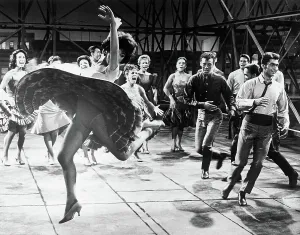 Drucke von Rita Moreno als Anita tanzt wild und wirkt sich auf ihre Hüfte hinweg schlagend mit Mitgliedern einer puertorikanischen Gang und deren Begleiterinnen im Rahmen eines Szenens aus dem Musical 'West Rita Drucke: Rita Moreno tanzt mit dem Stab des Westside-Storien