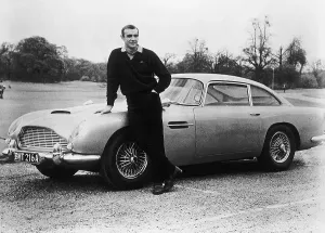 Drucke von Schauspieler Sean Connery, der originale James Bond ist hier auf dem Set von Goldfinger mit einer der fiktiven Spione-Fahrzeuge abgebildet. Es handelt sich um einen 1964er Aston Martin DB5 Film und Filmplakate: Sean Connery mit der Aston Martin von 007
