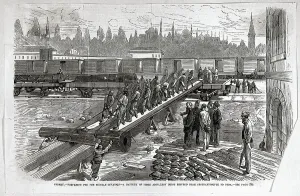 Arbeiter beladen Panzerbatterie auf Zug