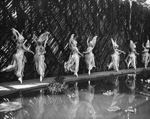 Frauen im Schmuckkleid tanzen am Teich