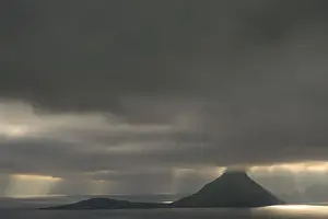 Dramatischer Stimmungslichtschnitt mit niedrigen Wolkenkämmen und Strahlen von Licht auf das Meer; Kultur; Utøyar; Färöer Inseln