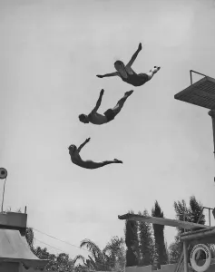 Drucke von Zwei Frauen und ein Mann im Luftbogen nach dem Sprung vom Hochsprunganlage am Ambassador-Lido-Pool in Los Angeles, Kalifornien um die Jahr 1940s. (Fotografie von Keystone View / FPG / Getty Images) Historische Drucke Erzählen Geschichten Aus Vergangenen Zeiten Drucke: Mit dem Sprungbrett
