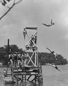 Drucke von Ein Gruppenbild von Personen, die auf einen Sprungbrett warten, um etwa 1930 gesehen zu werden. (Fotografie von Keystone View / FPG / Getty Images) Historische Drucke Erzählen Geschichten Aus Vergangenen Zeiten Drucke: Mit dem Tauchbrett zu arbeiten