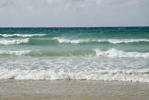 Windy Day At The Beach Drucke: Spray blown by high winds, rolling crushers