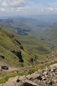 Ein Fahrzeug fährt entlang einer Piste durch die Hügel des Sani-Passes im Drakensbergschutzgebiet in der Provinz KwaZulu-Natal Südafrika